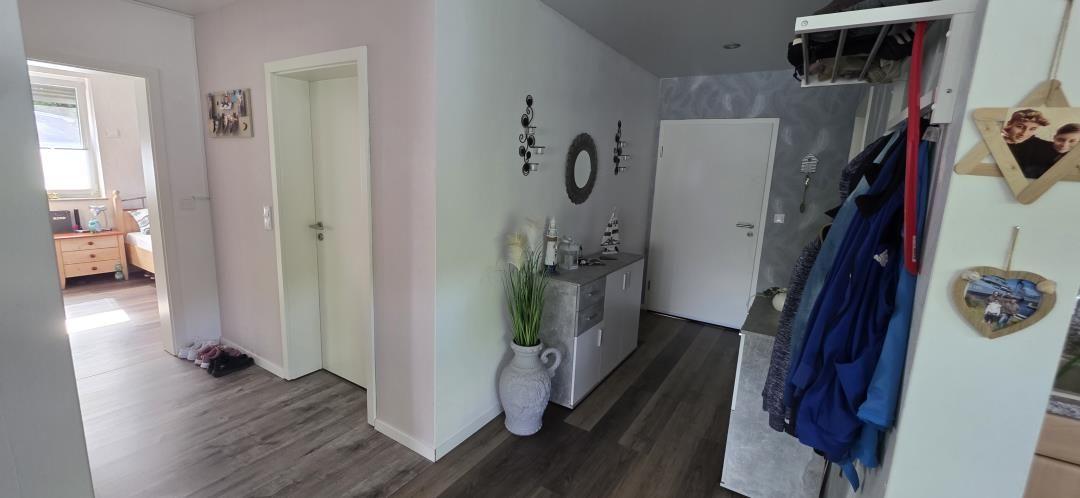Flur mit Kleiderständer, Pflanze und Blick in Schlafzimmer