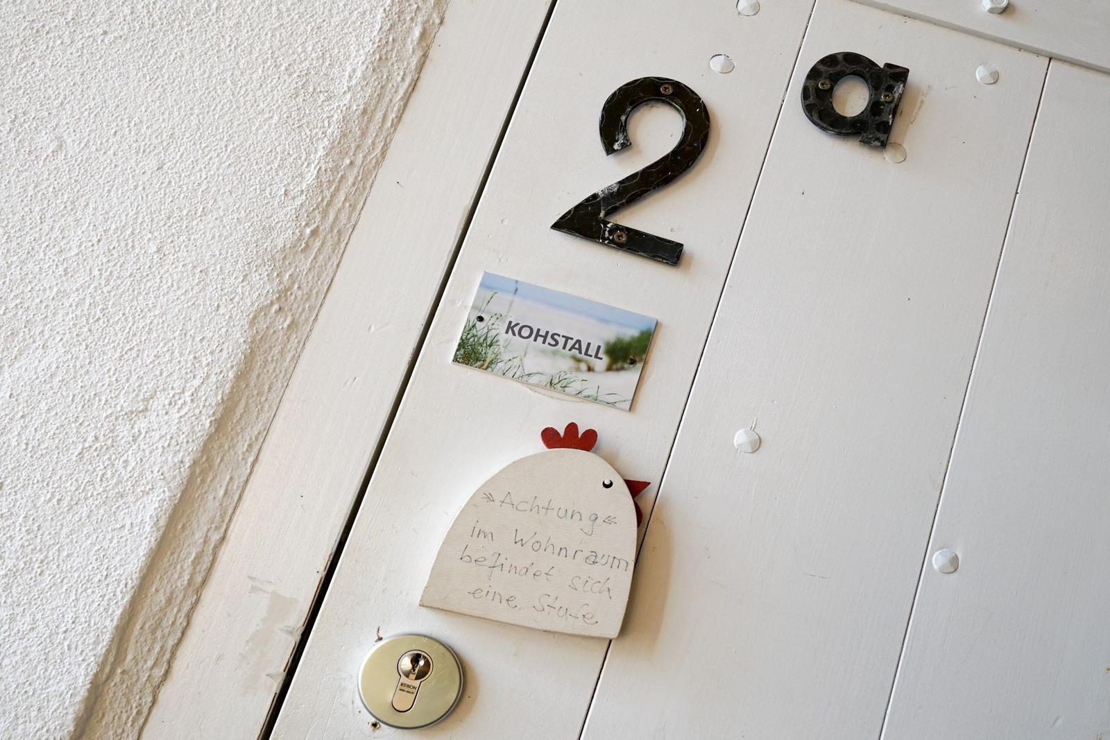Tür mit Hausnummer 2a und Hinweis auf Stufe im Wohnraum.