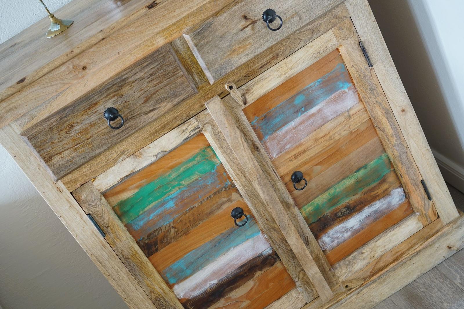 Holzschrank mit farbigen Türen und schwarzen Ringgriffen