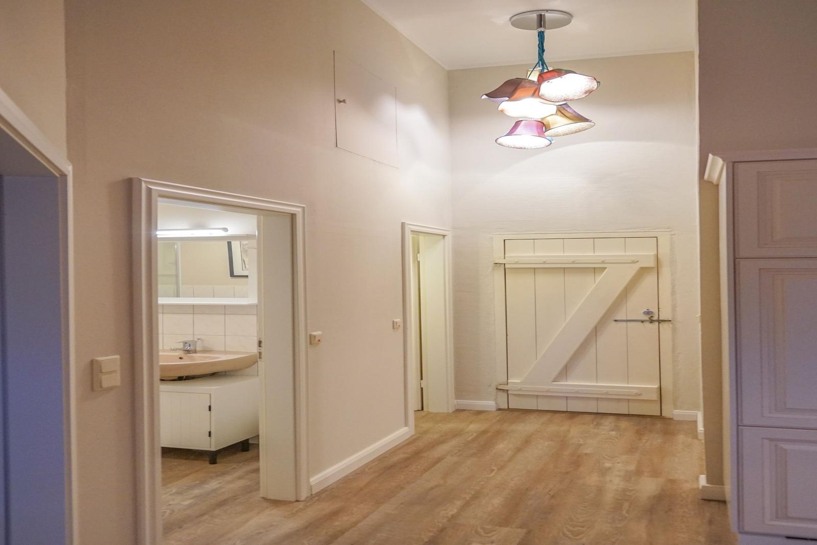 Flur mit Holzboden, Badezimmer und Stalltor