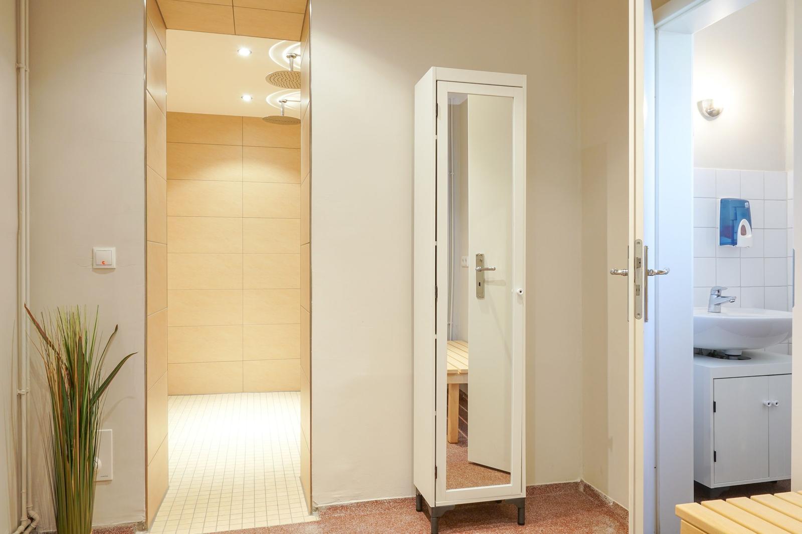 Dusche, Kleiderschrank und Waschbeckenbereich in einem Badezimmer