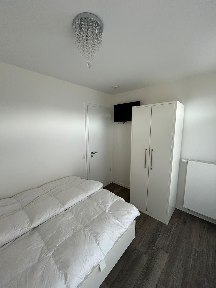 Schlafzimmer mit Bett, Kleiderschrank und Deckenventilator