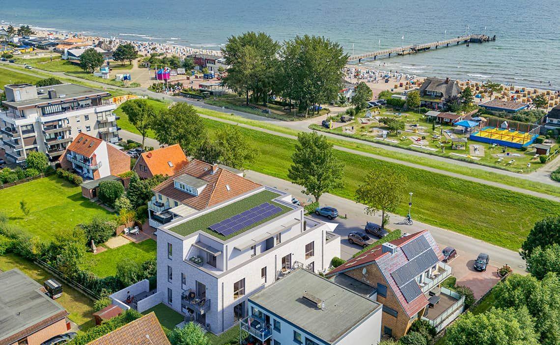 Modernes Haus mit Solaranlage, Blick auf Strand und Pier.