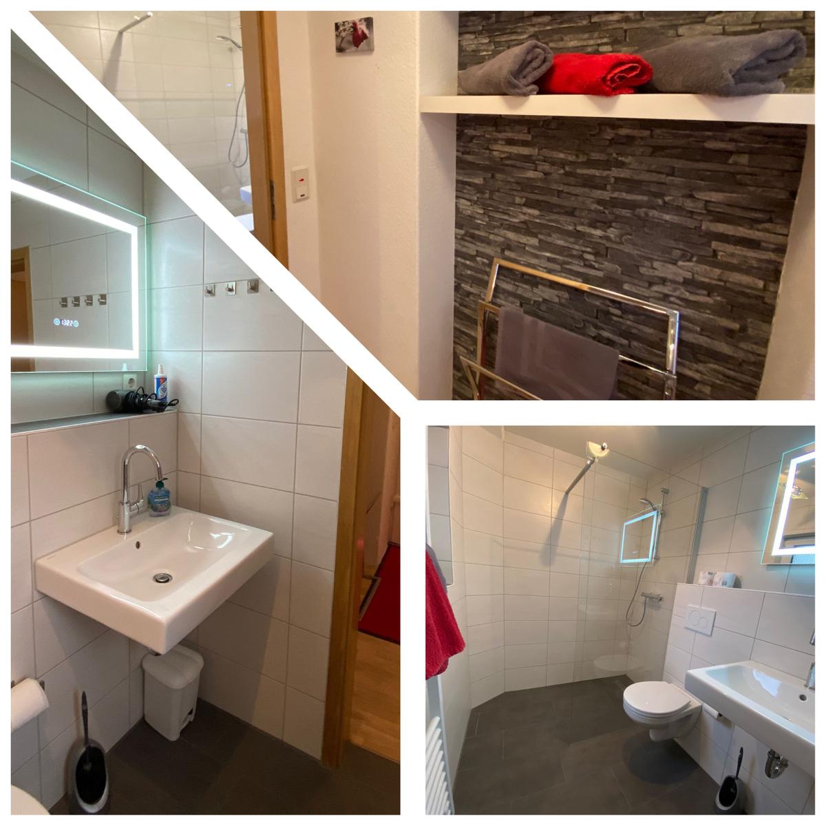 Badezimmer mit Dusche, Waschbecken und Toilette. Handtuchhalter und Badewanne sind vorhanden.