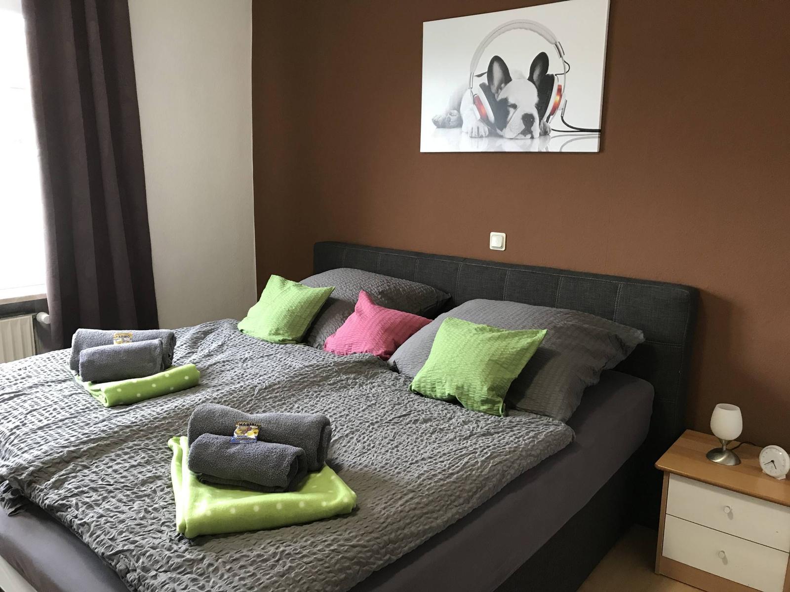 Schlafzimmer mit Bett, Kissen und Bild an der Wand.