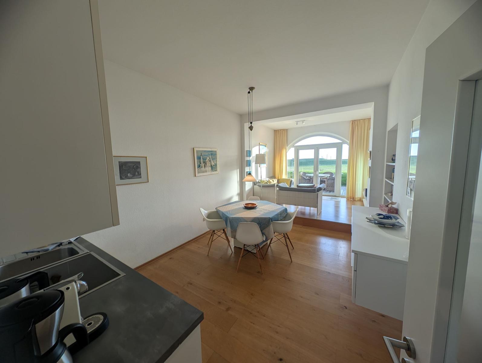 Küche mit Essbereich und Blick auf Wohnzimmer mit Terrasse.