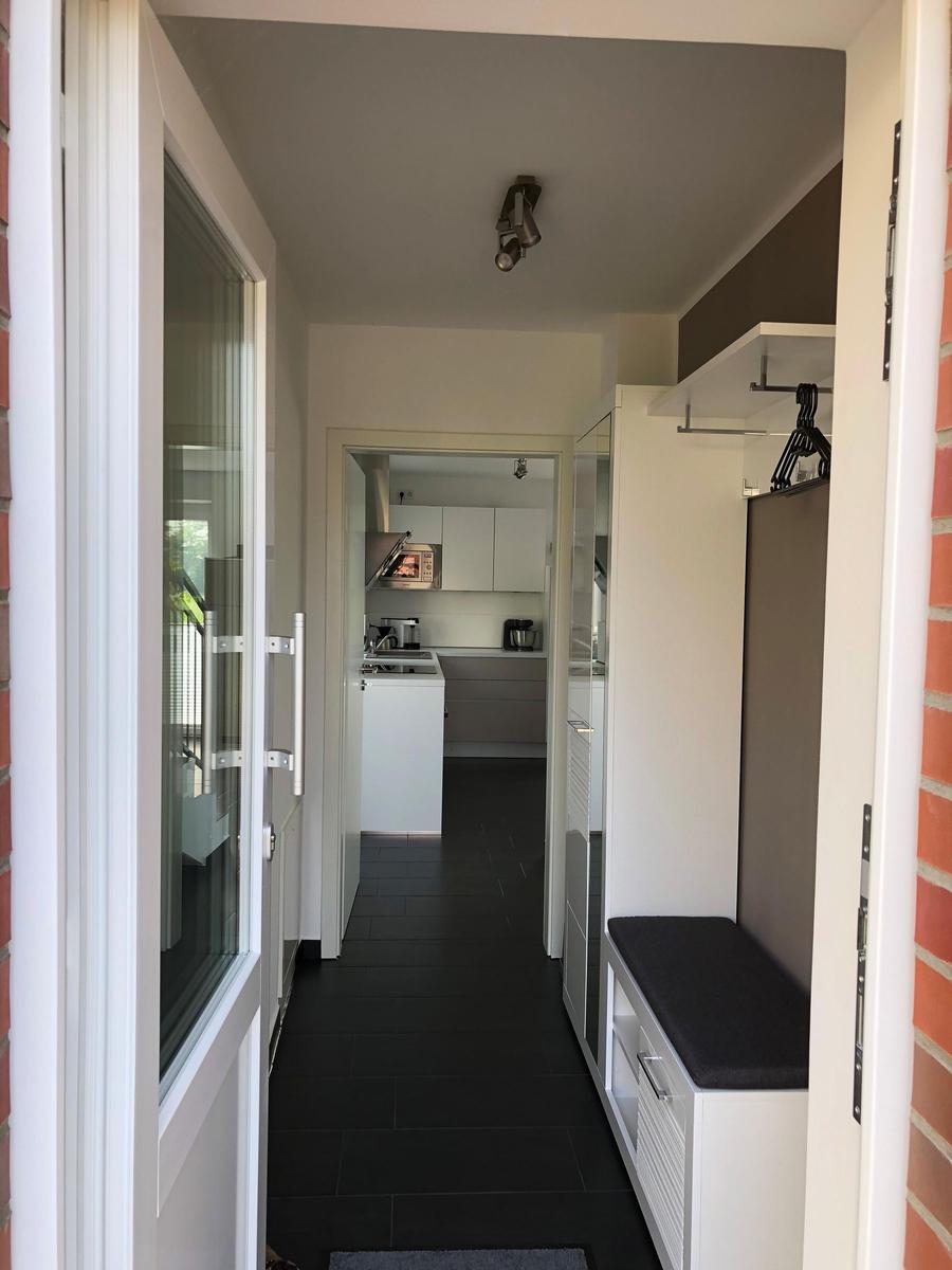 Eingangsbereich mit Garderobe und Blick in die Küche.