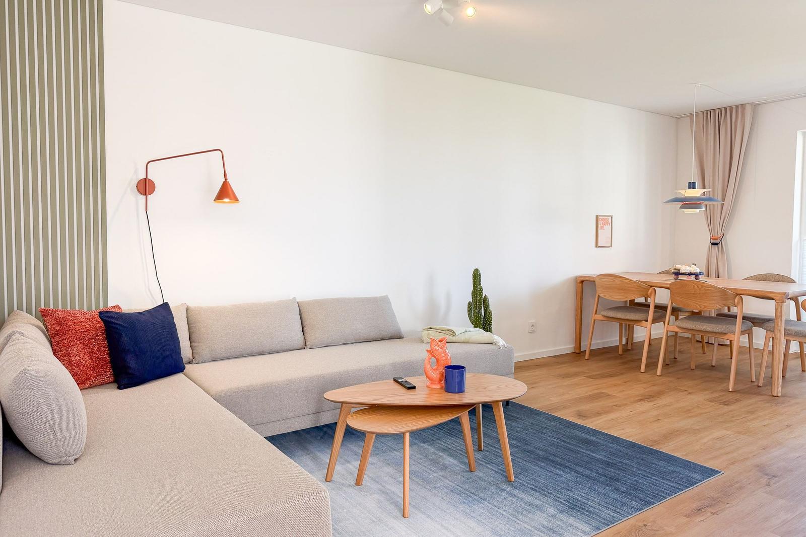 Wohn- und Essbereich mit Sofa, Tisch und Stühlen.