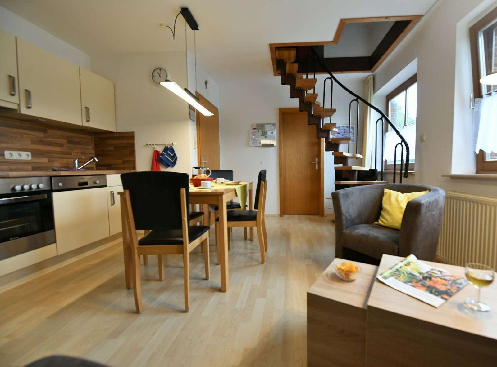 Küche, Essbereich und Wohnzimmer mit Holzboden und Treppe.