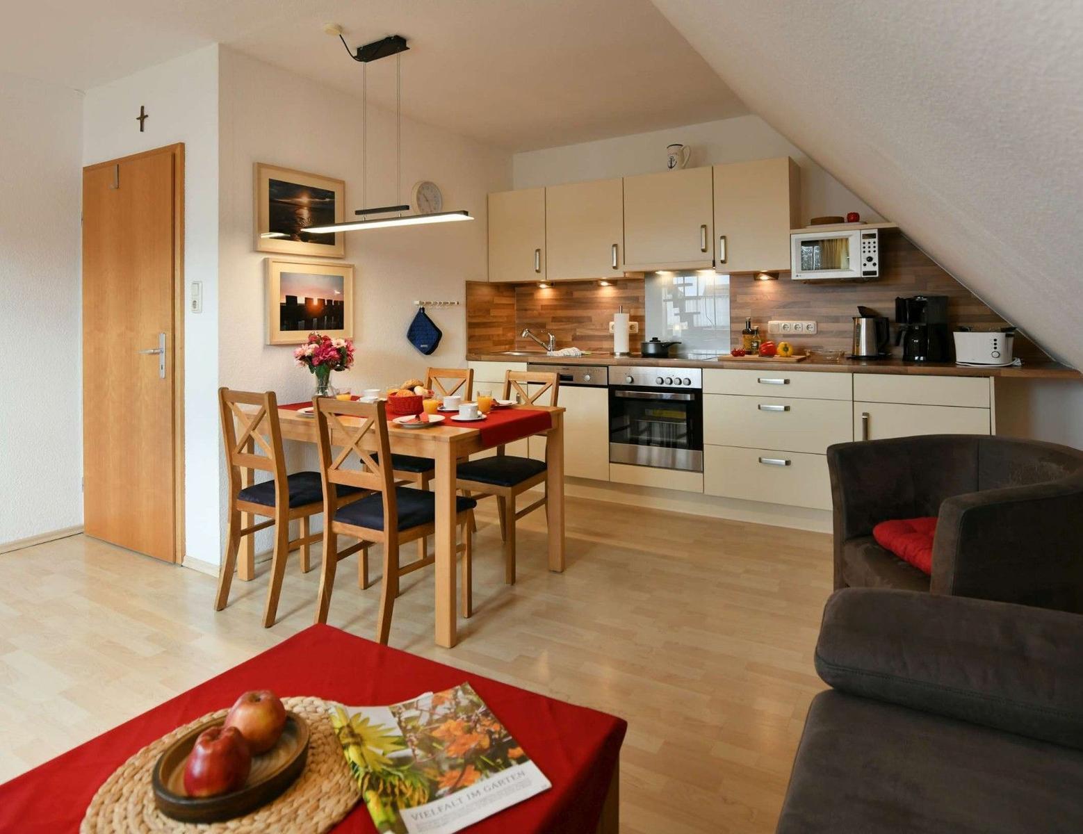 Küche mit Essbereich und Sofa unter Dachschräge