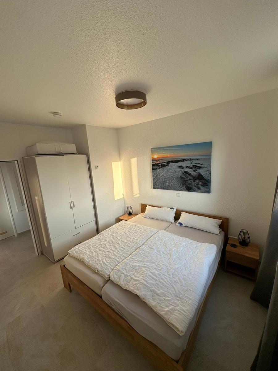 Schlafzimmer mit Doppelbett, Kleiderschrank und Wandbild