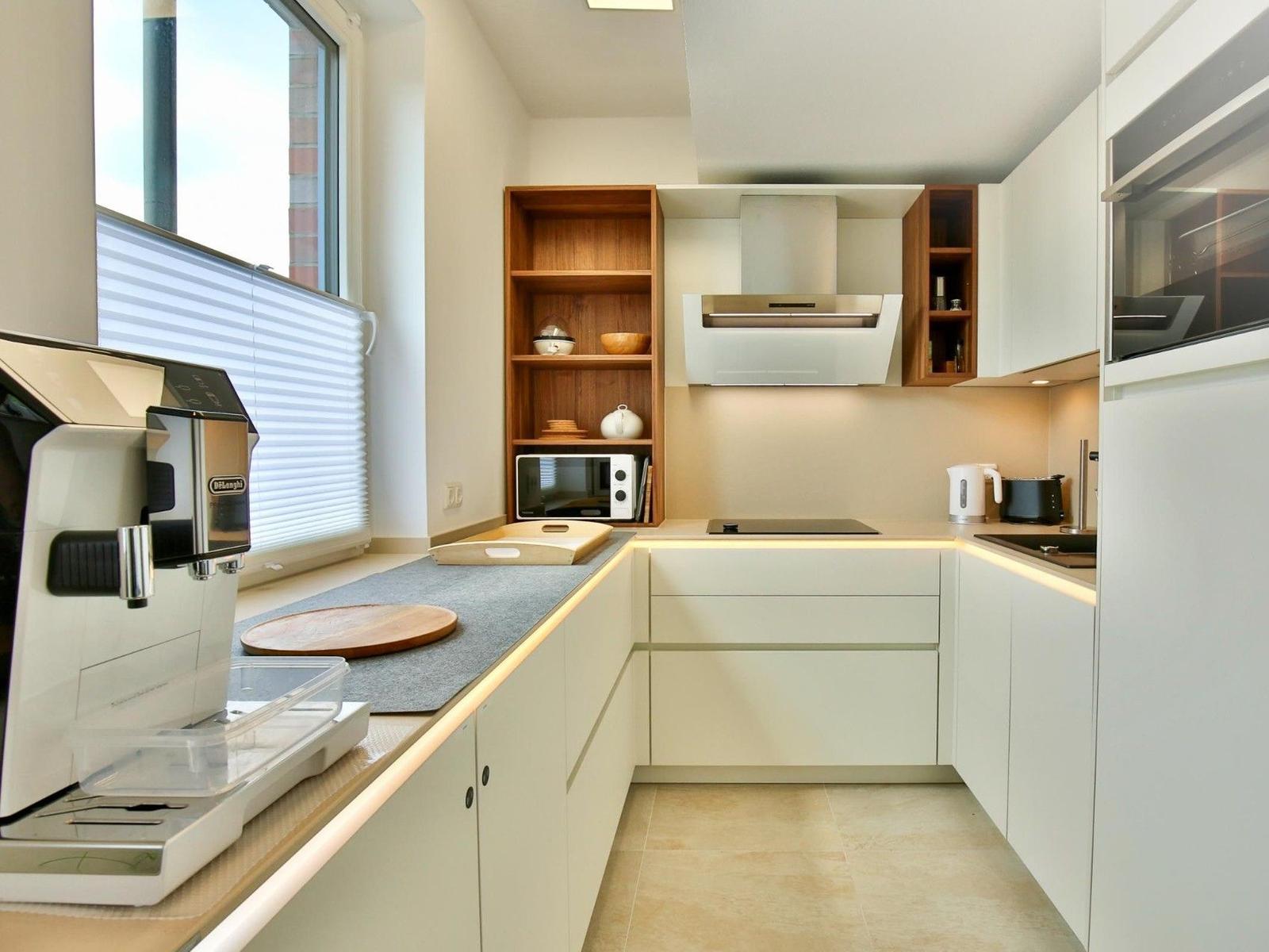 Moderne Küche mit weißen Schränken, Holzregalen und integriertem Kühlschrank.