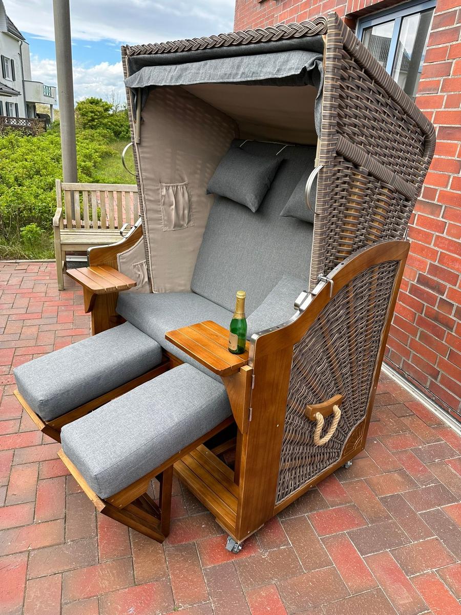 Große Strandliege mit Sitzfläche und Fußstützen auf Terrasse.