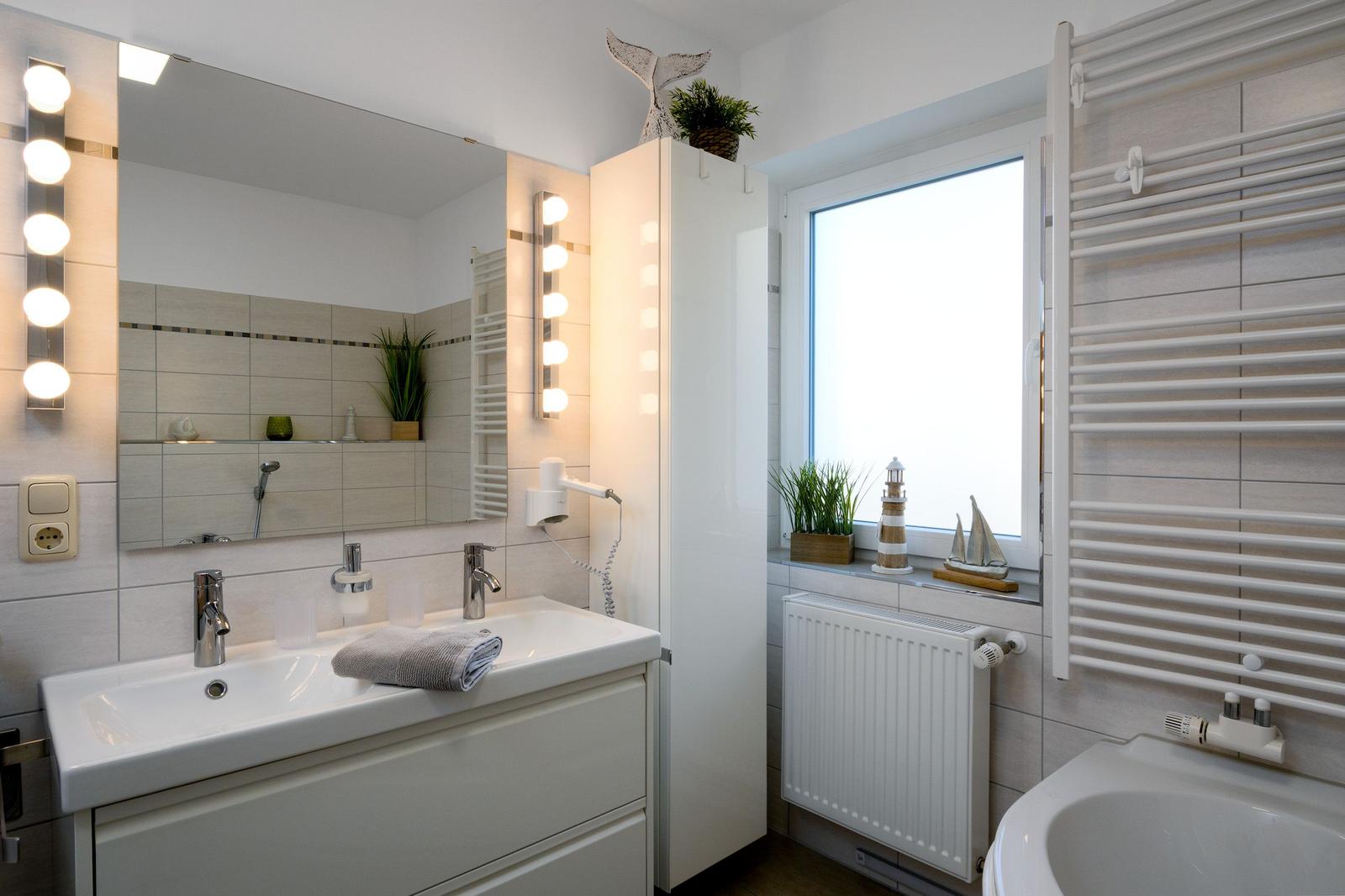 Badezimmer mit Waschbecken, Spiegel, Dusche und Fenster
