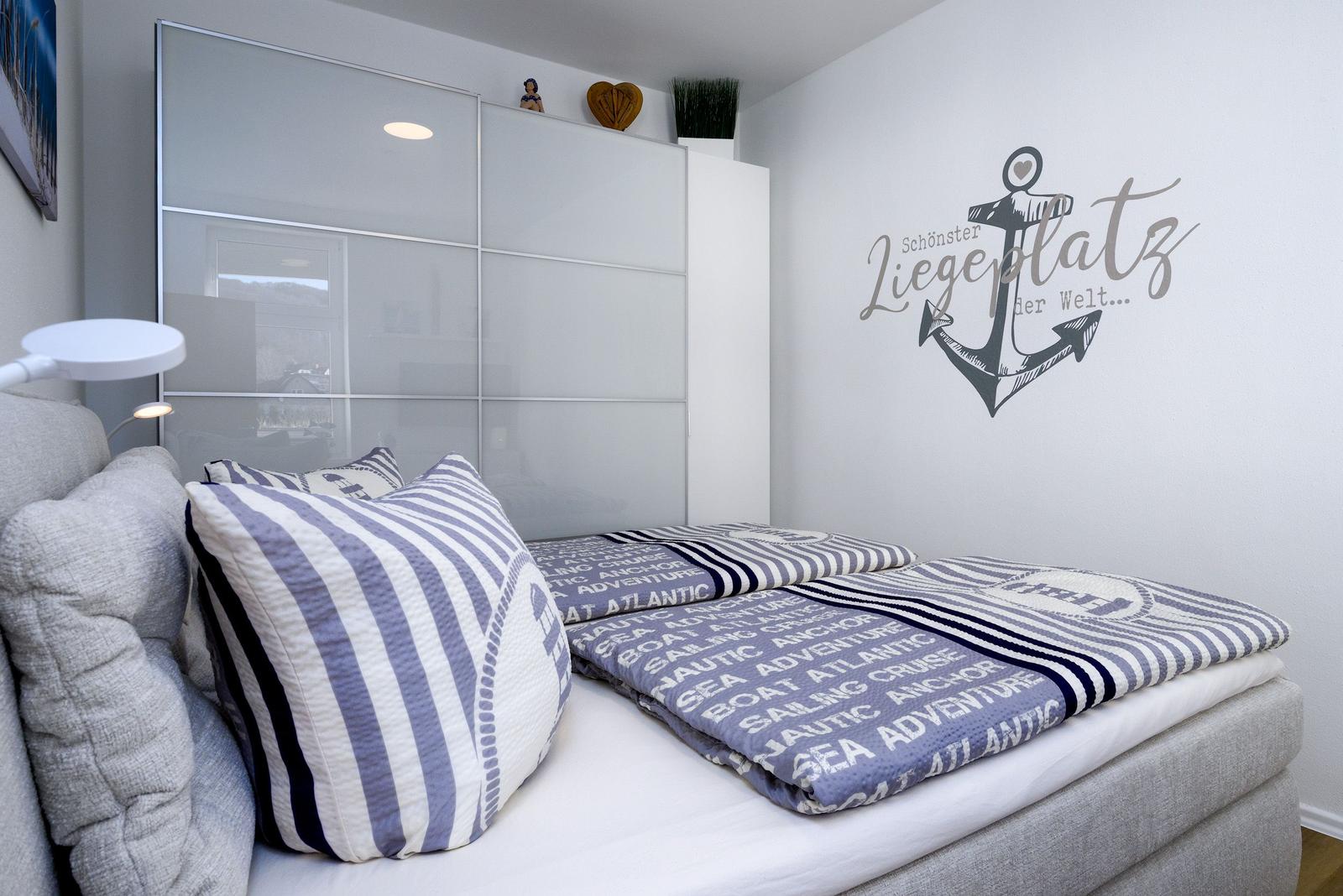 Schlafzimmer mit Bett, Wanddekoration und Schrank