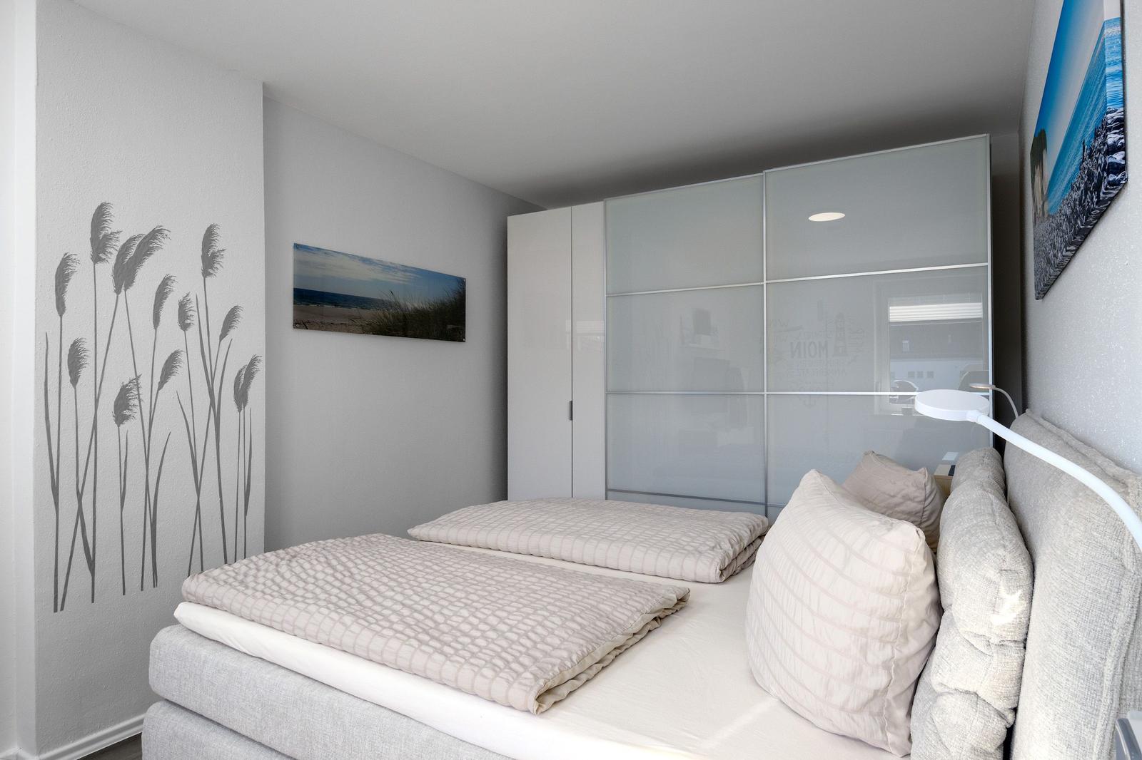 Schlafzimmer mit Doppelbett, Glaswand und Wanddekoration