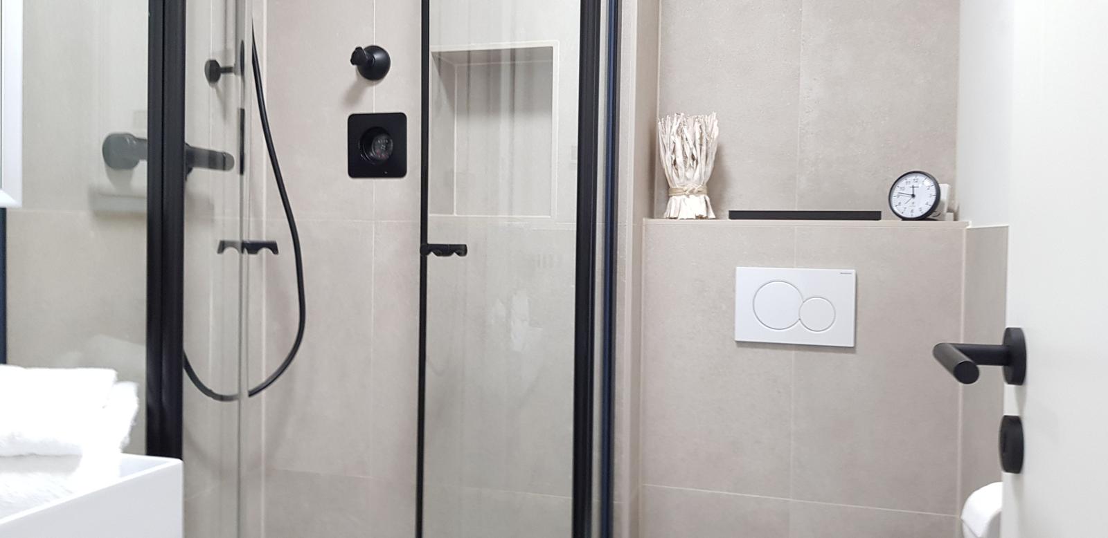 Dusche mit Glaswand, Toilette und Badewanne im Badezimmer