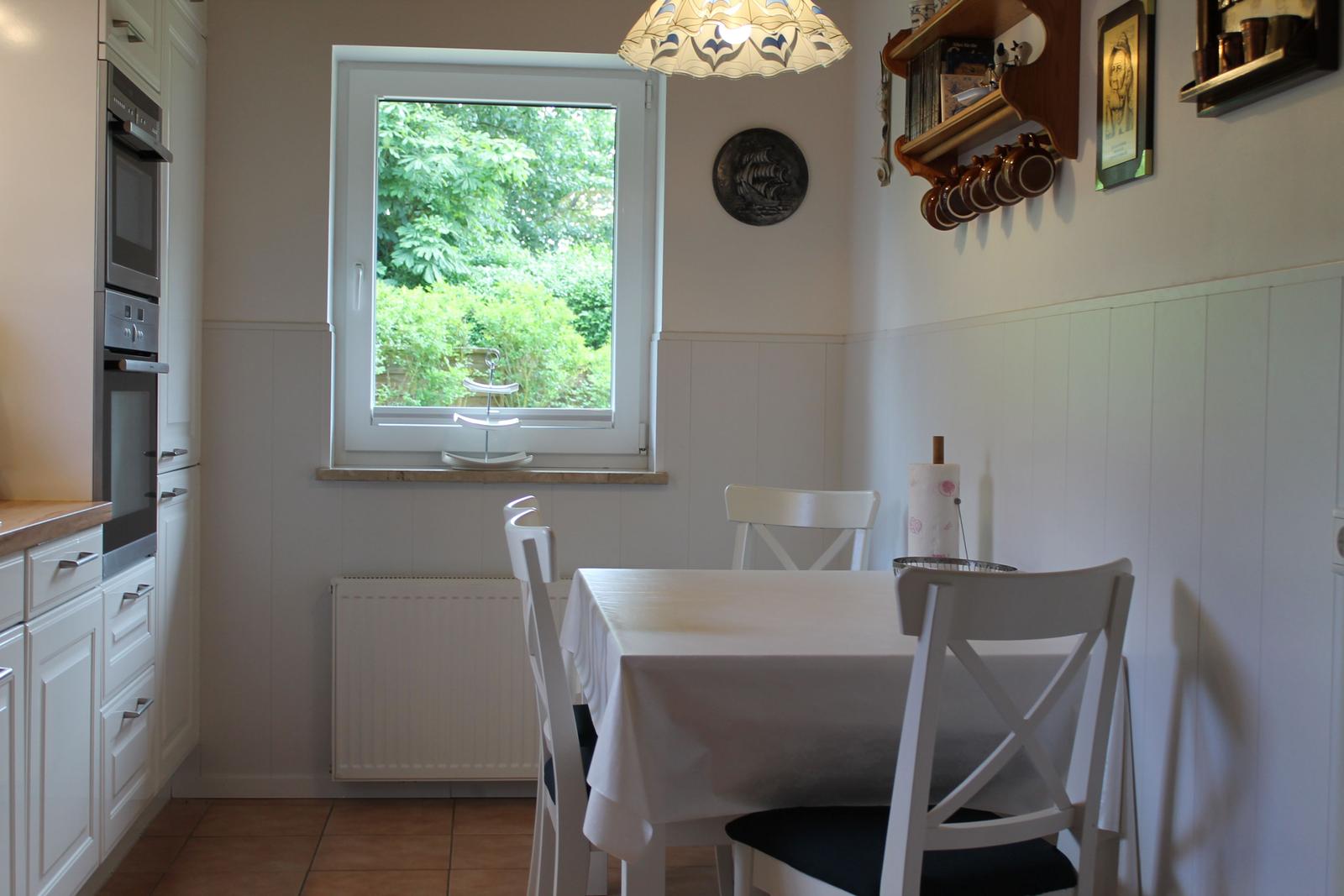 Küchenbereich mit Tisch, Stühlen und Fenster zum Garten
