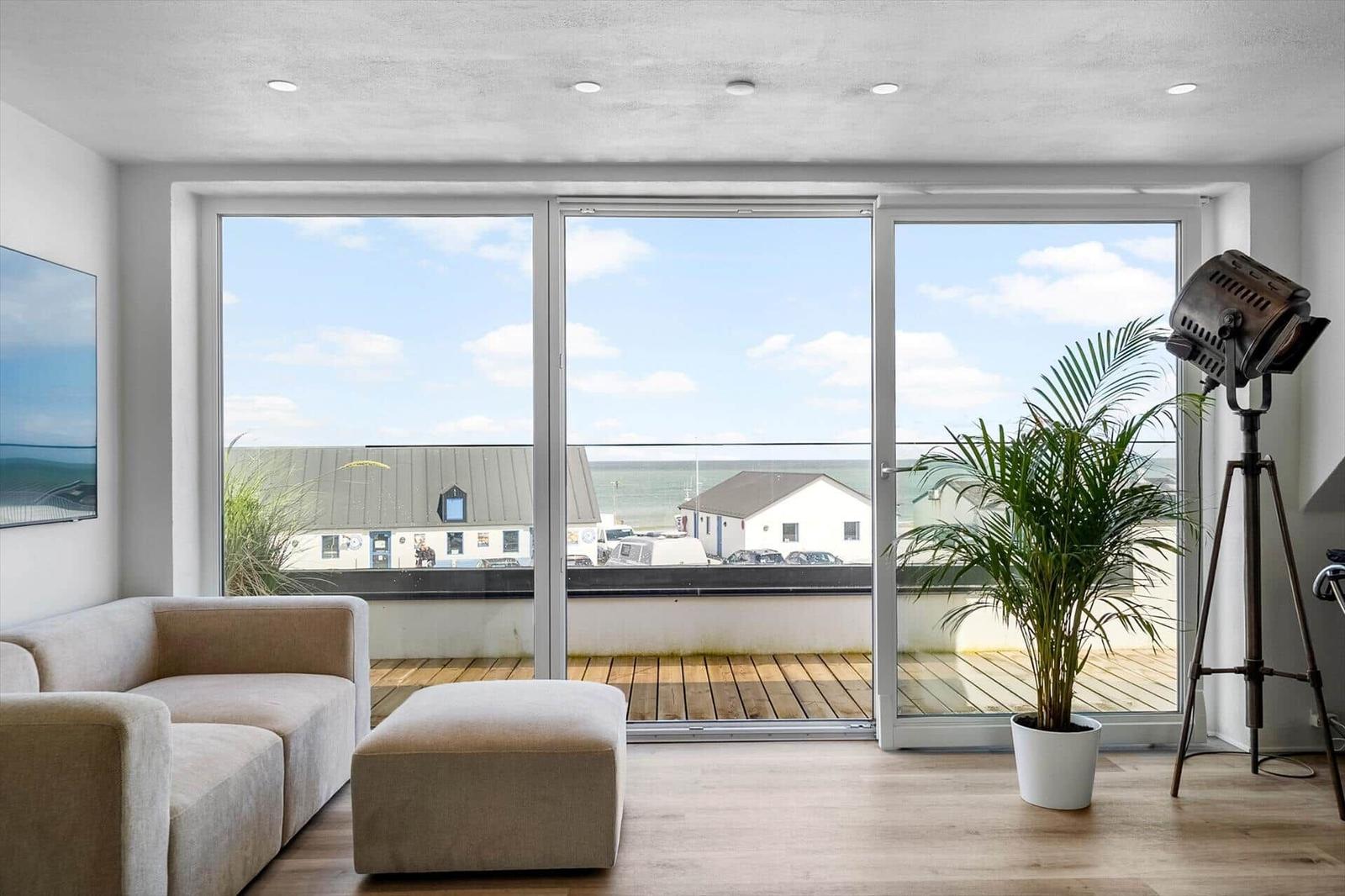 Wohnzimmer mit großem Fenster und Blick auf den Hafen.