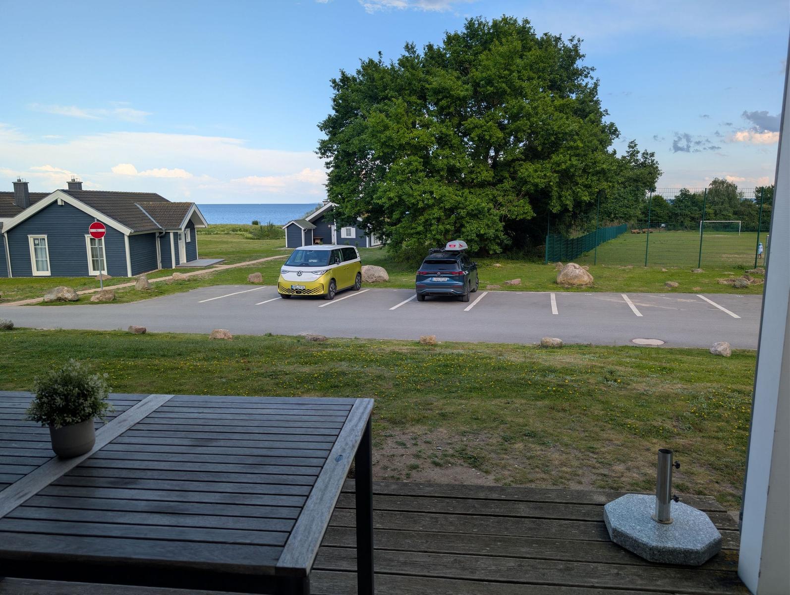 Terrasse mit Tisch, Blick auf Parkplatz und See