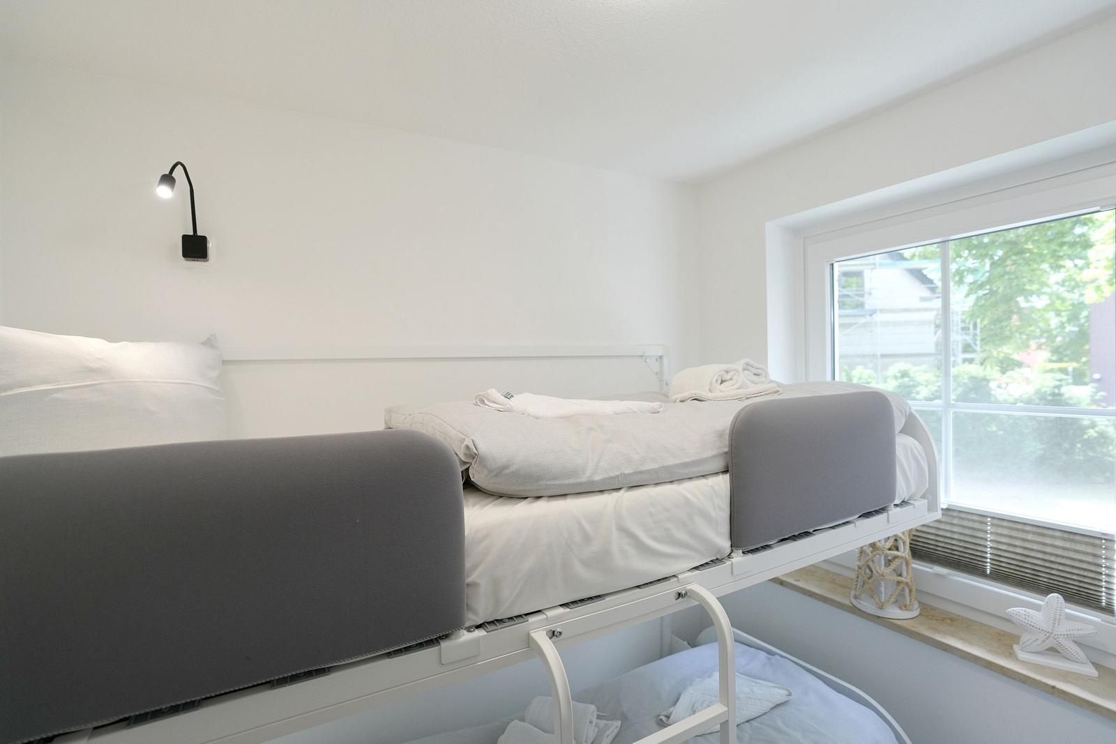 Obere Schlafcouch mit grauen Seiten und Fensterblick