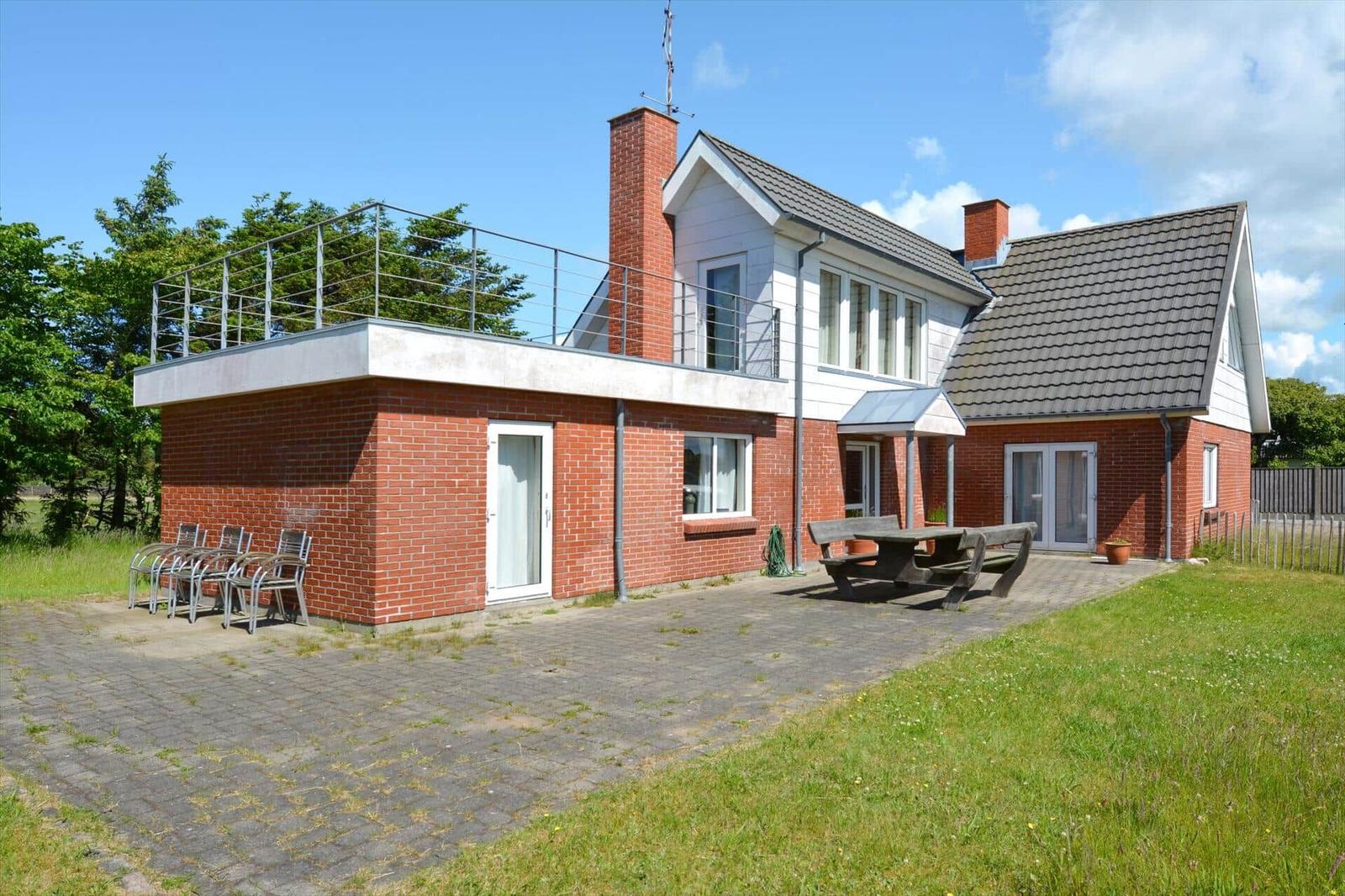 Zwei-stöckiges Haus mit Terrasse, Grillplatz und Gartenbereich.