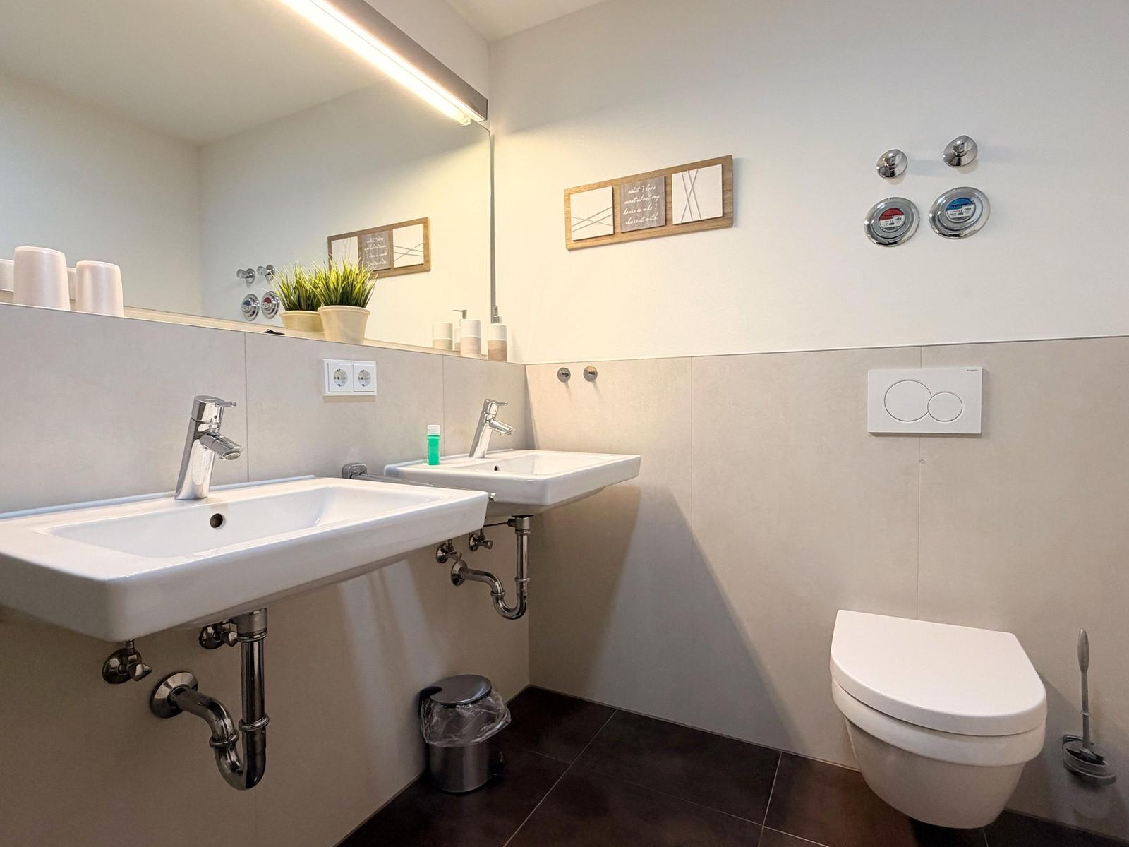 Badezimmer mit zwei Waschbecken, Spiegel und WC
