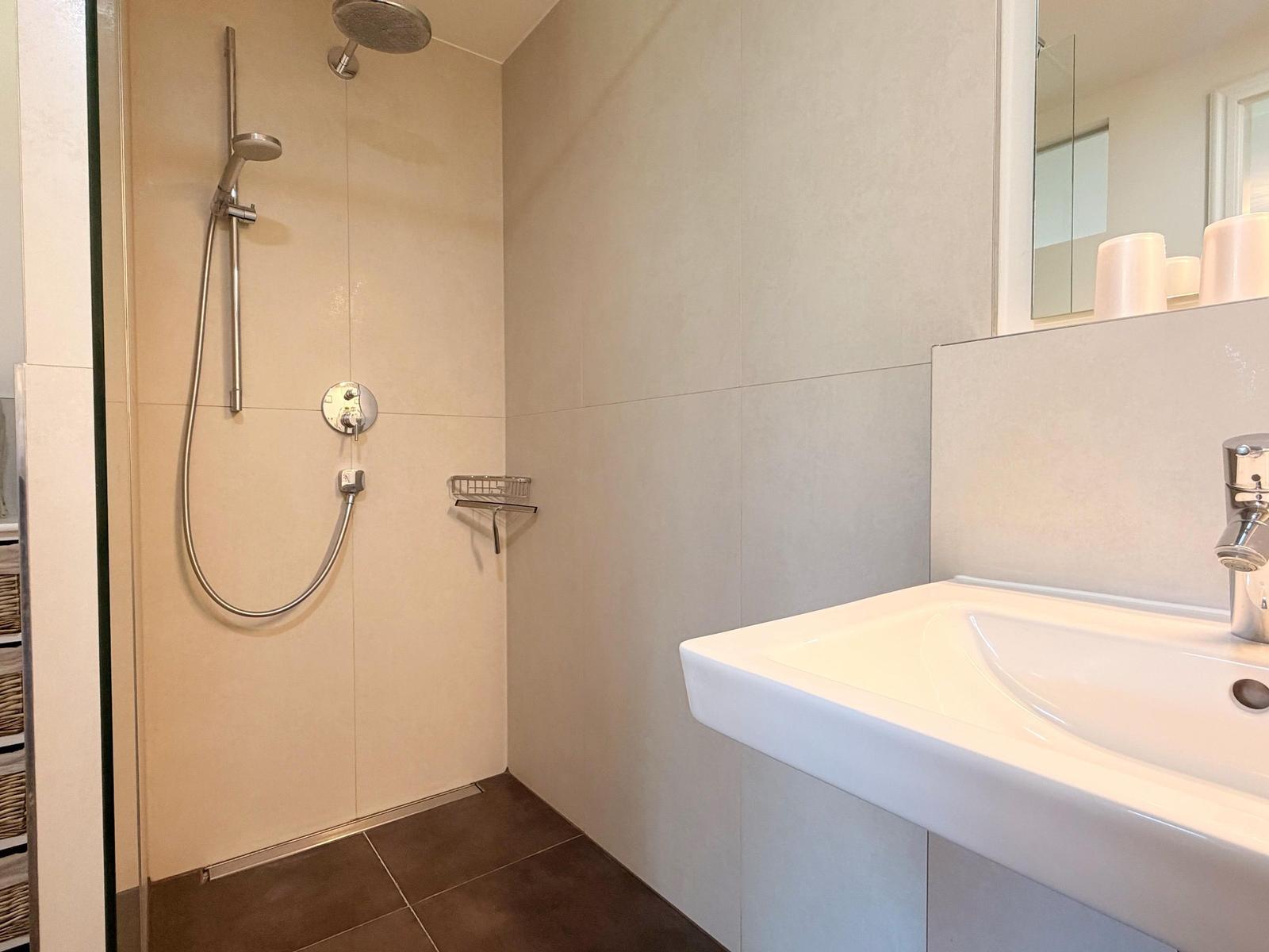 Badezimmer mit Dusche und Waschbecken