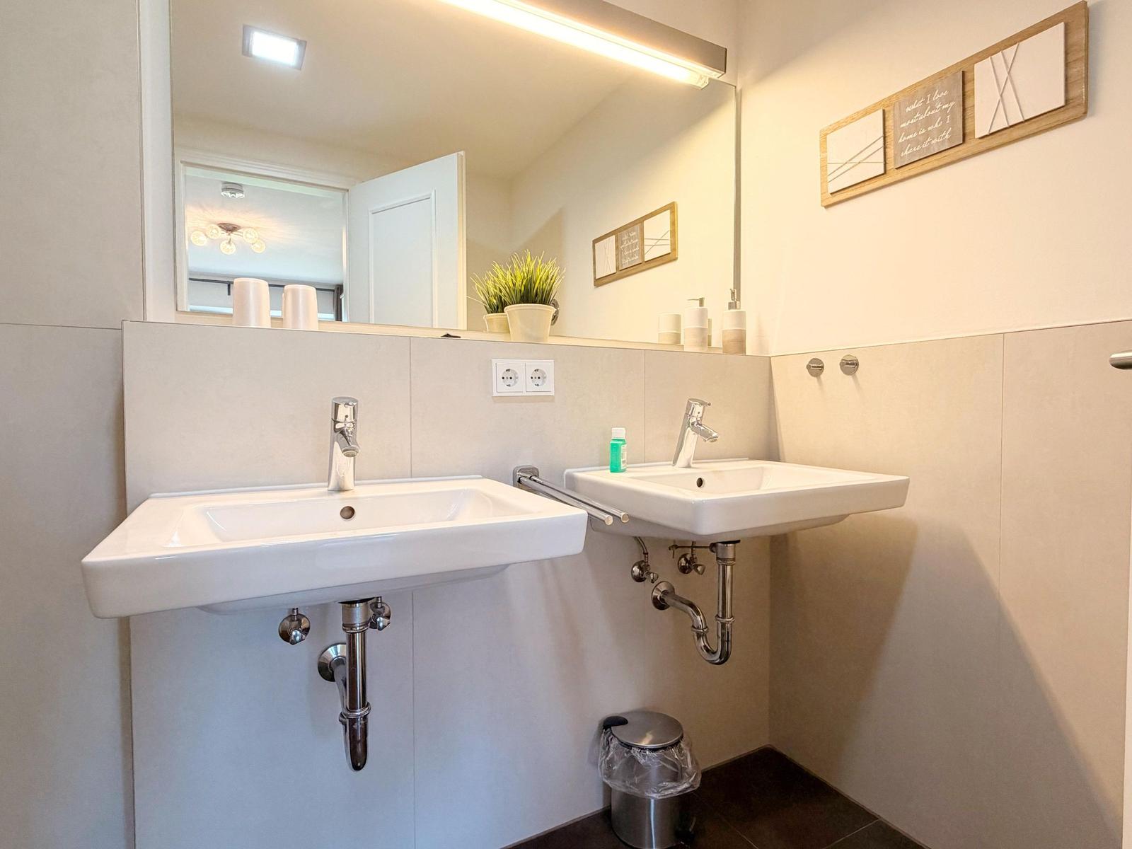 Zwei Waschbecken mit Spiegeln und Handtuchhaltern an der Wand.