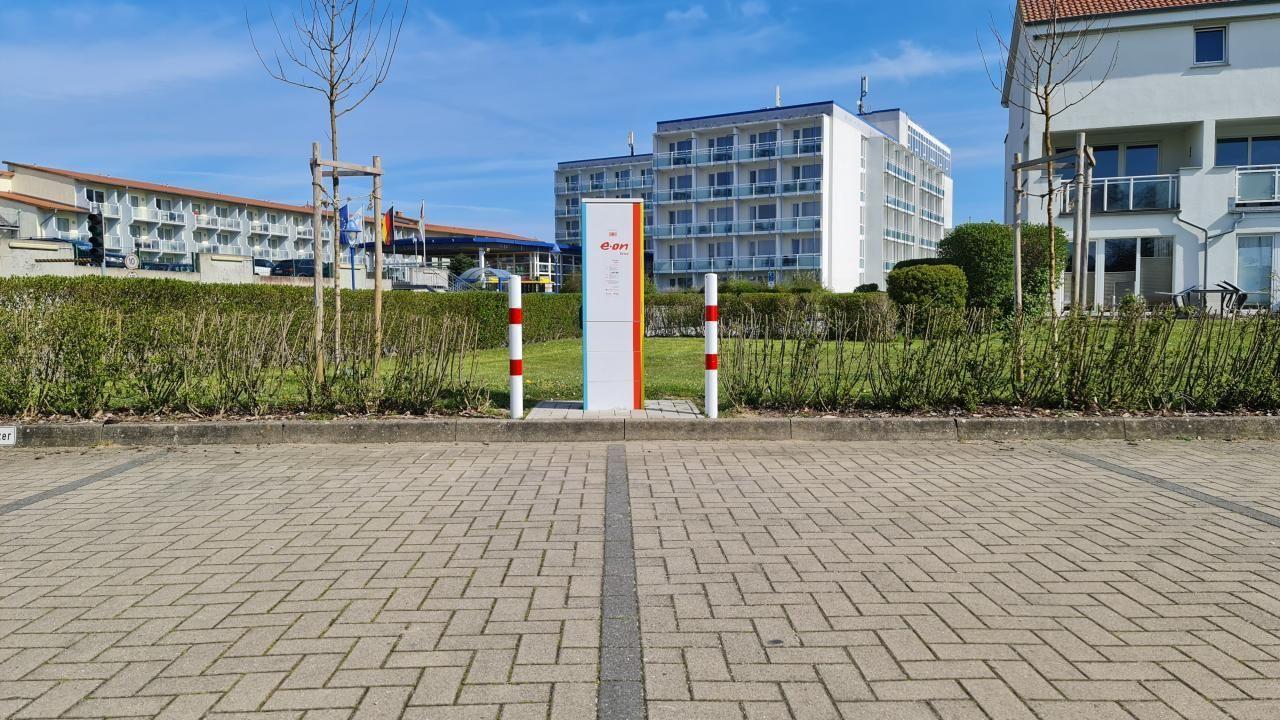 E-Station mit Parkplatz und Wohngebäuden im Hintergrund.