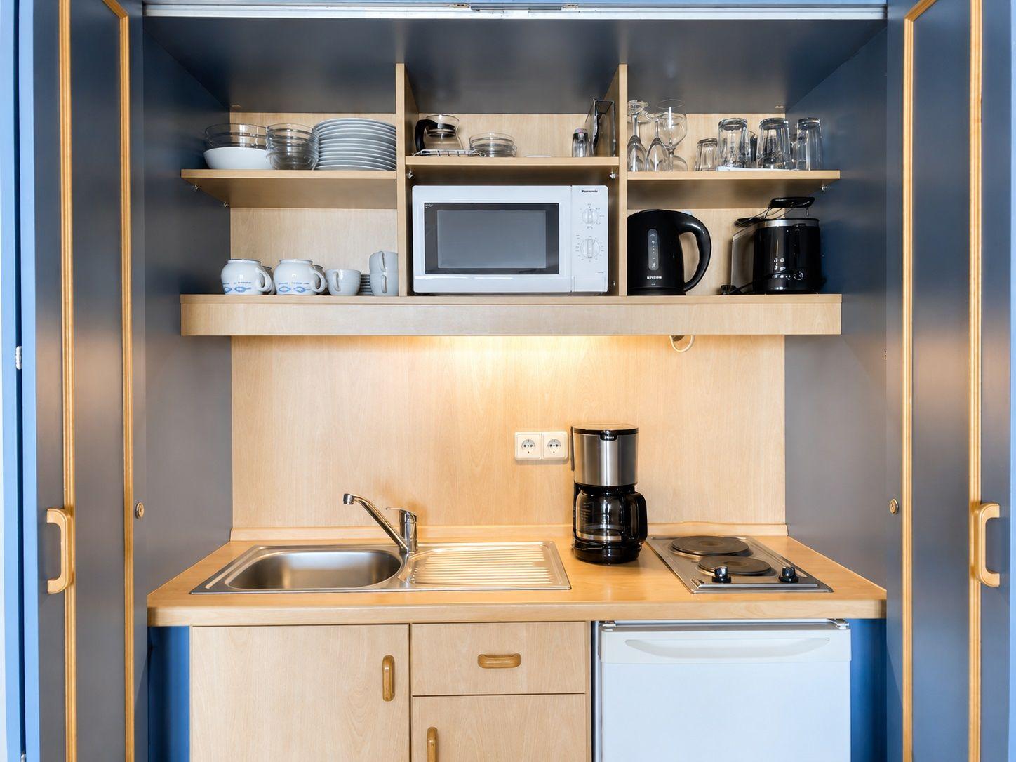 Küche mit Spüle, Herd, Kühlschrank und Küchenutensilien.