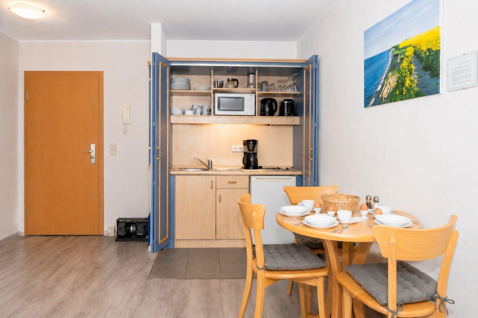 Küche mit Essbereich und Esszimmertisch mit Stühlen.