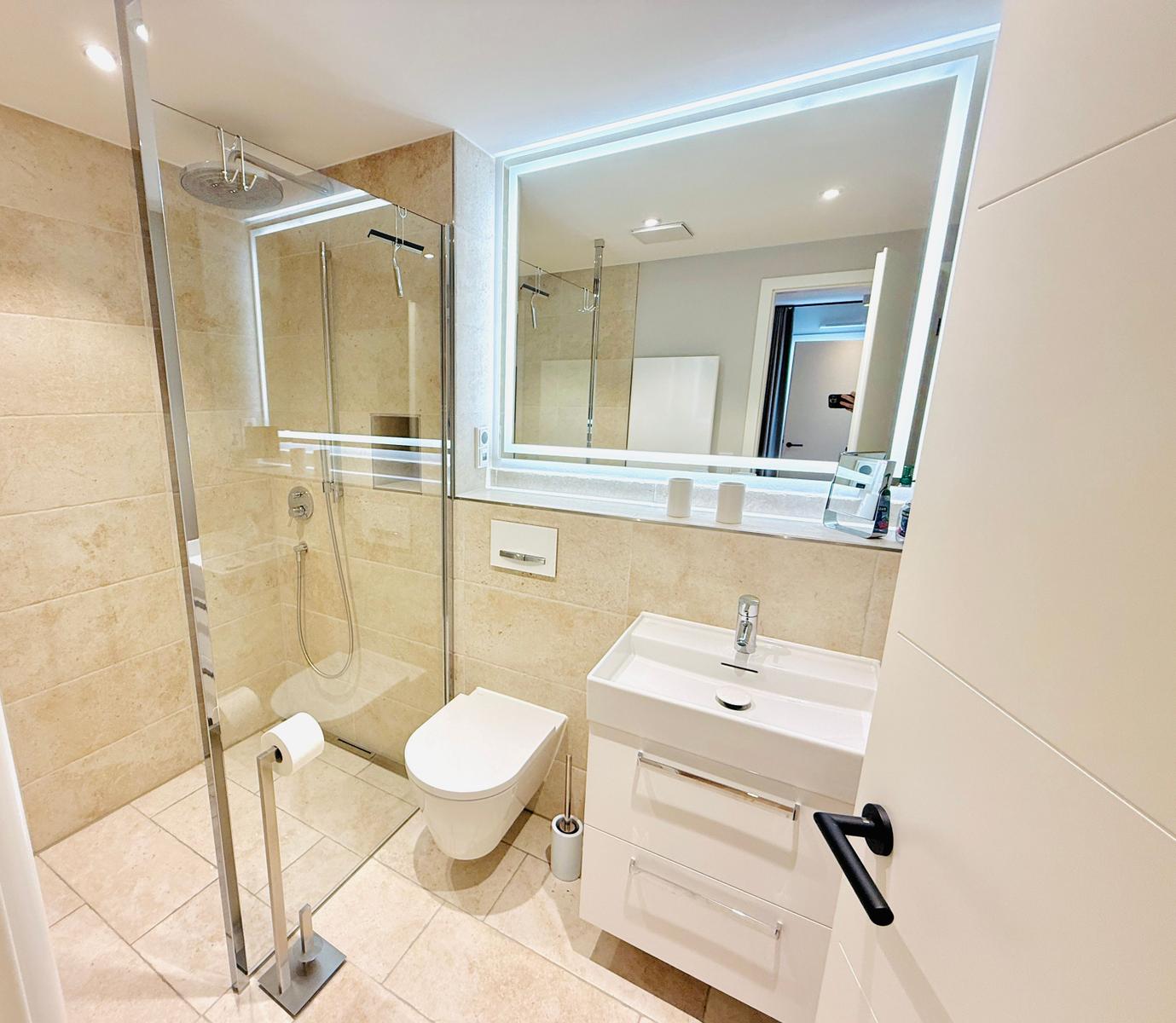 Moderne Badewanne mit Dusche, Waschbecken und Toilette.