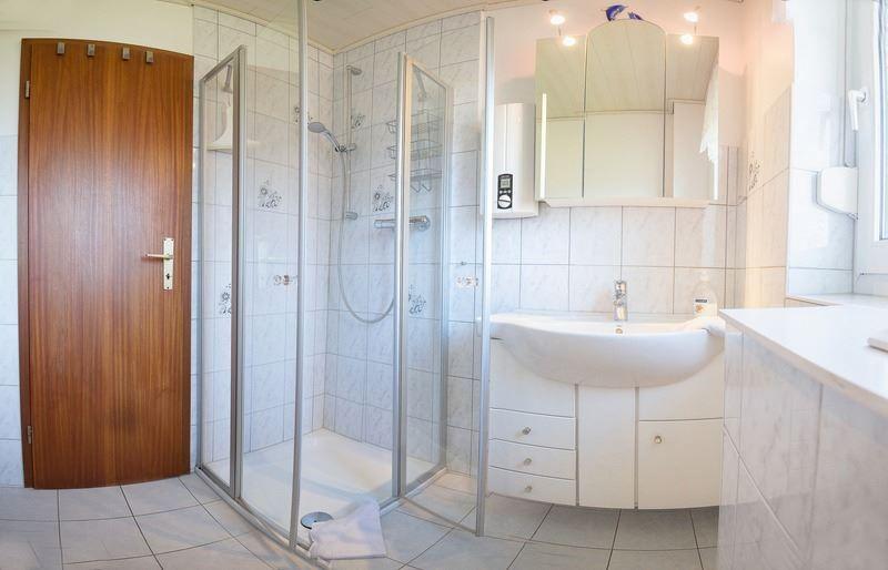 Bad mit Dusche, Waschbecken und Spiegelschrank