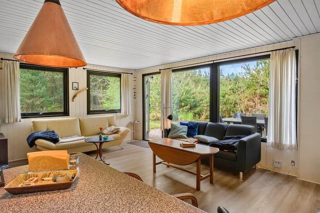 Wohnbereich mit Sofa, Couch und Blick auf Wald.