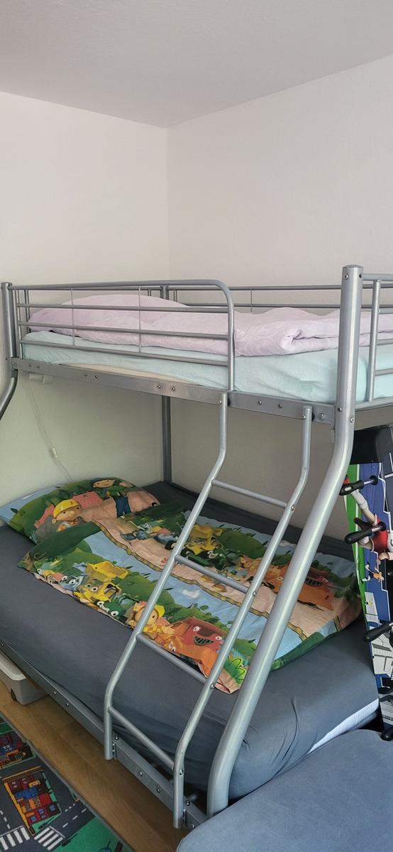 Zimmer mit Doppelstockbett, Matratzen und Kinderbettbezug.