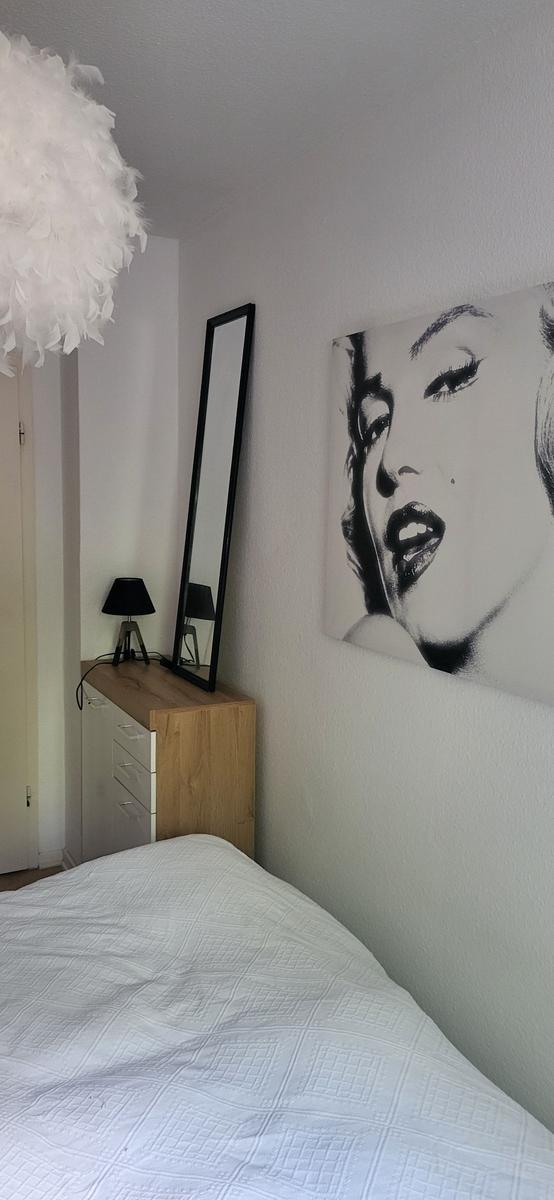 Schlafzimmer mit Bett, Spiegelschrank und Wandbild