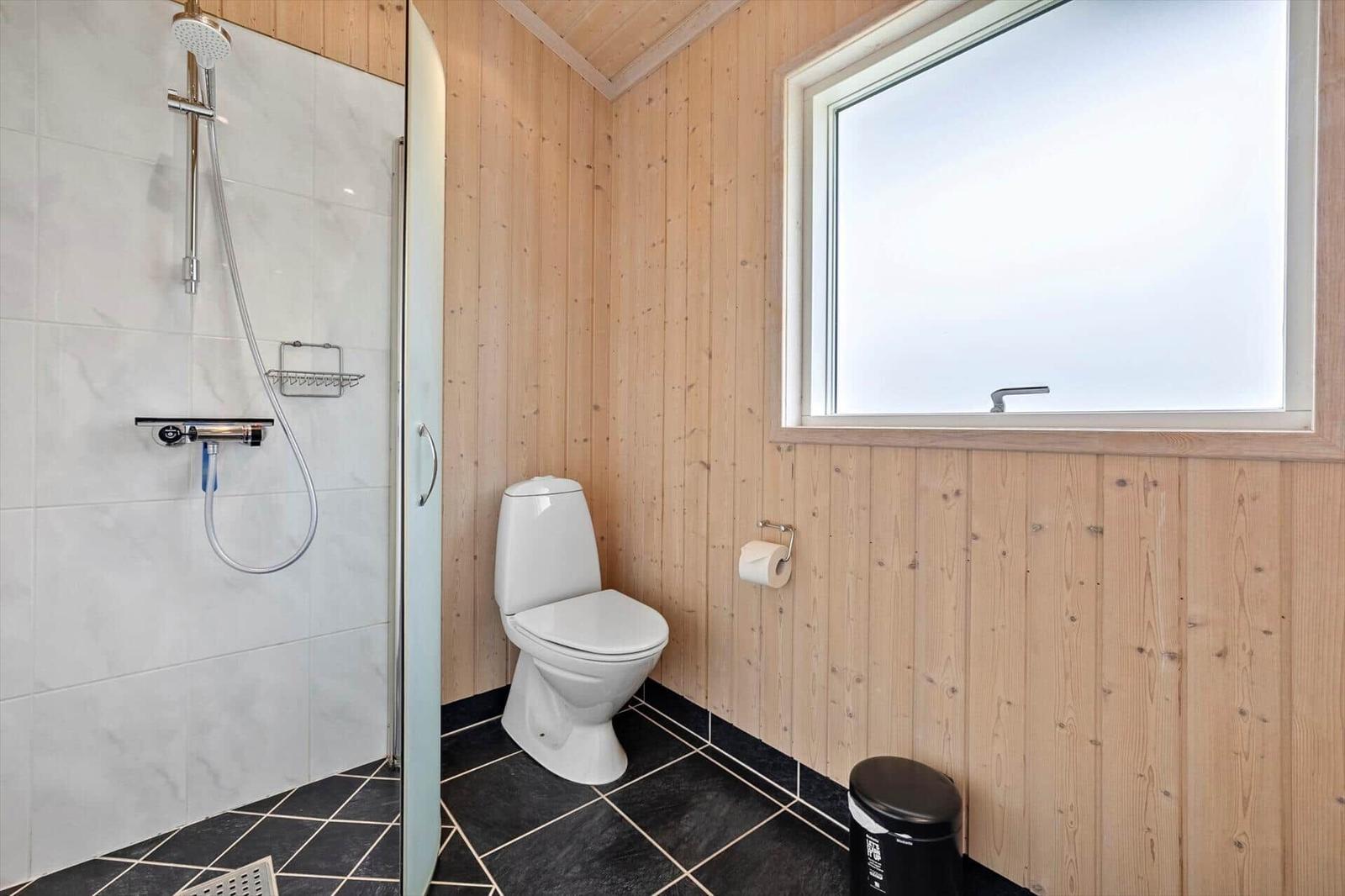 Bathroom with shower, toilet, and window
