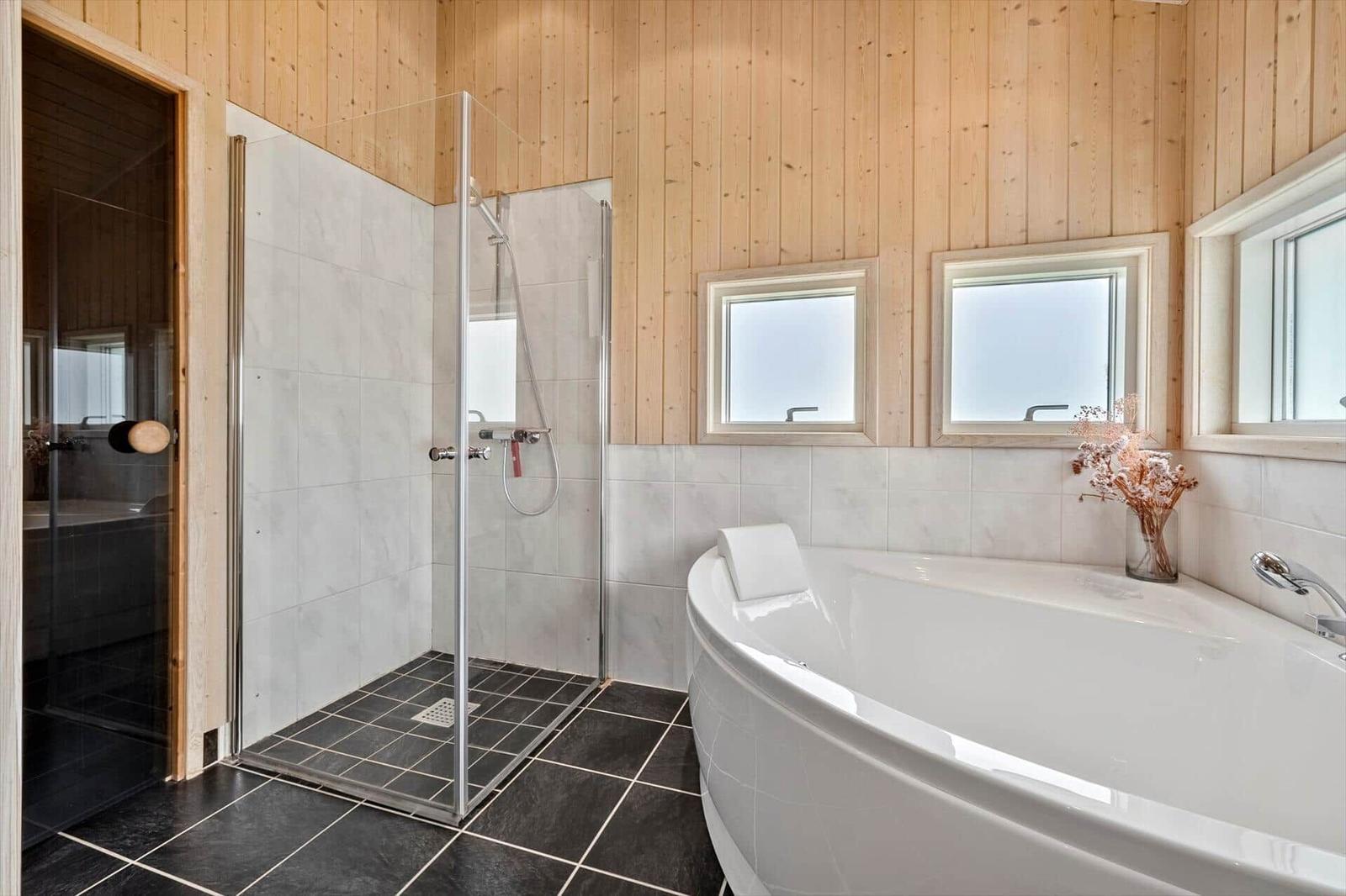 Bathroom with shower and bathtub, wooden walls and windows