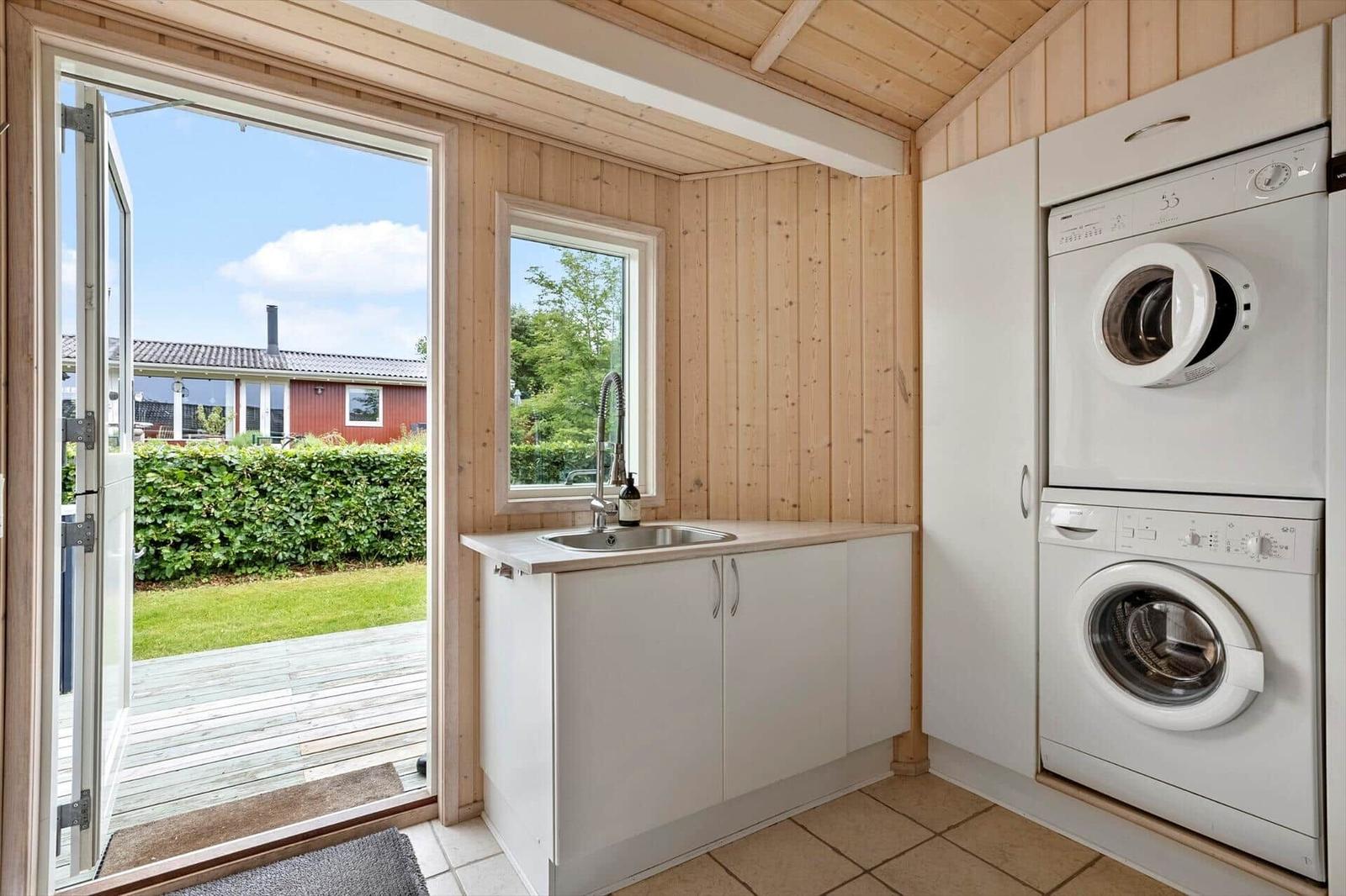 Apartment with washing machine and dryer, window and door to the garden.