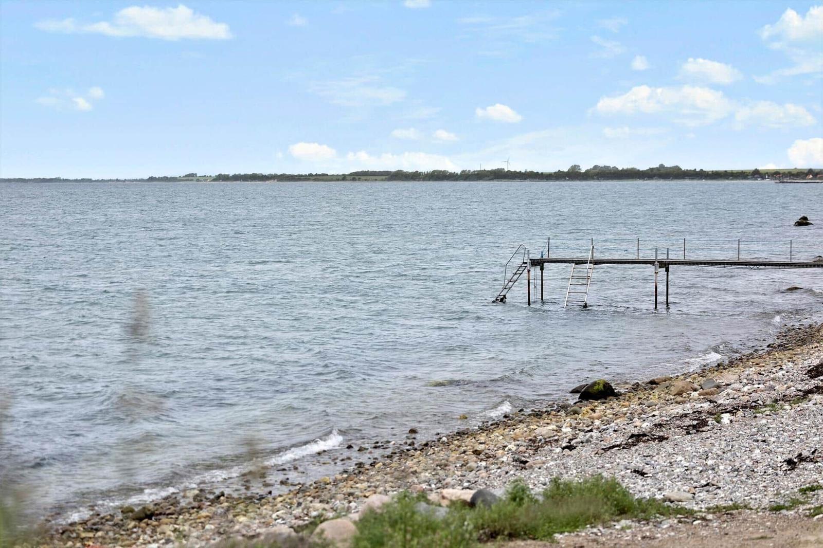 Rocky shore with pier and stairs into the water