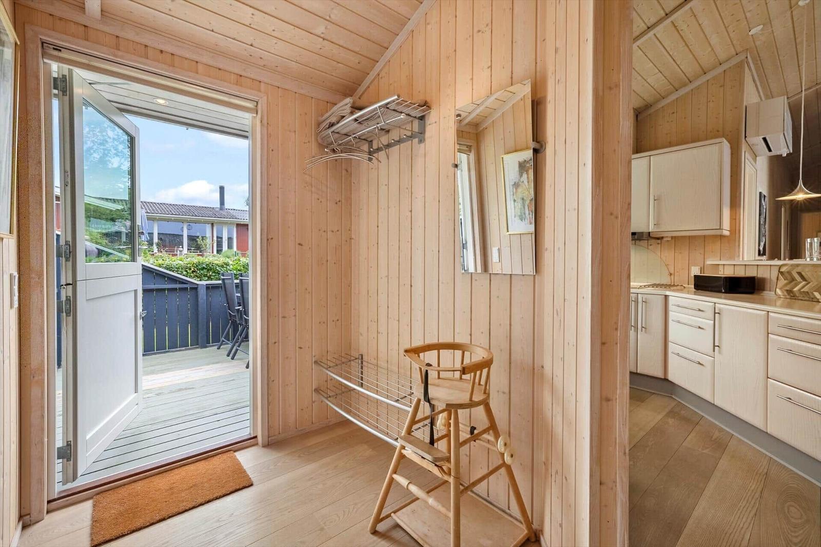Entryway with high chair, drying rack, and view to the terrace.