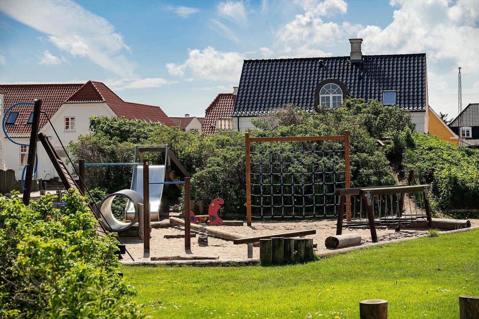 Kinderbereich mit Rutsche, Klettergerüst und Schaukel im Garten