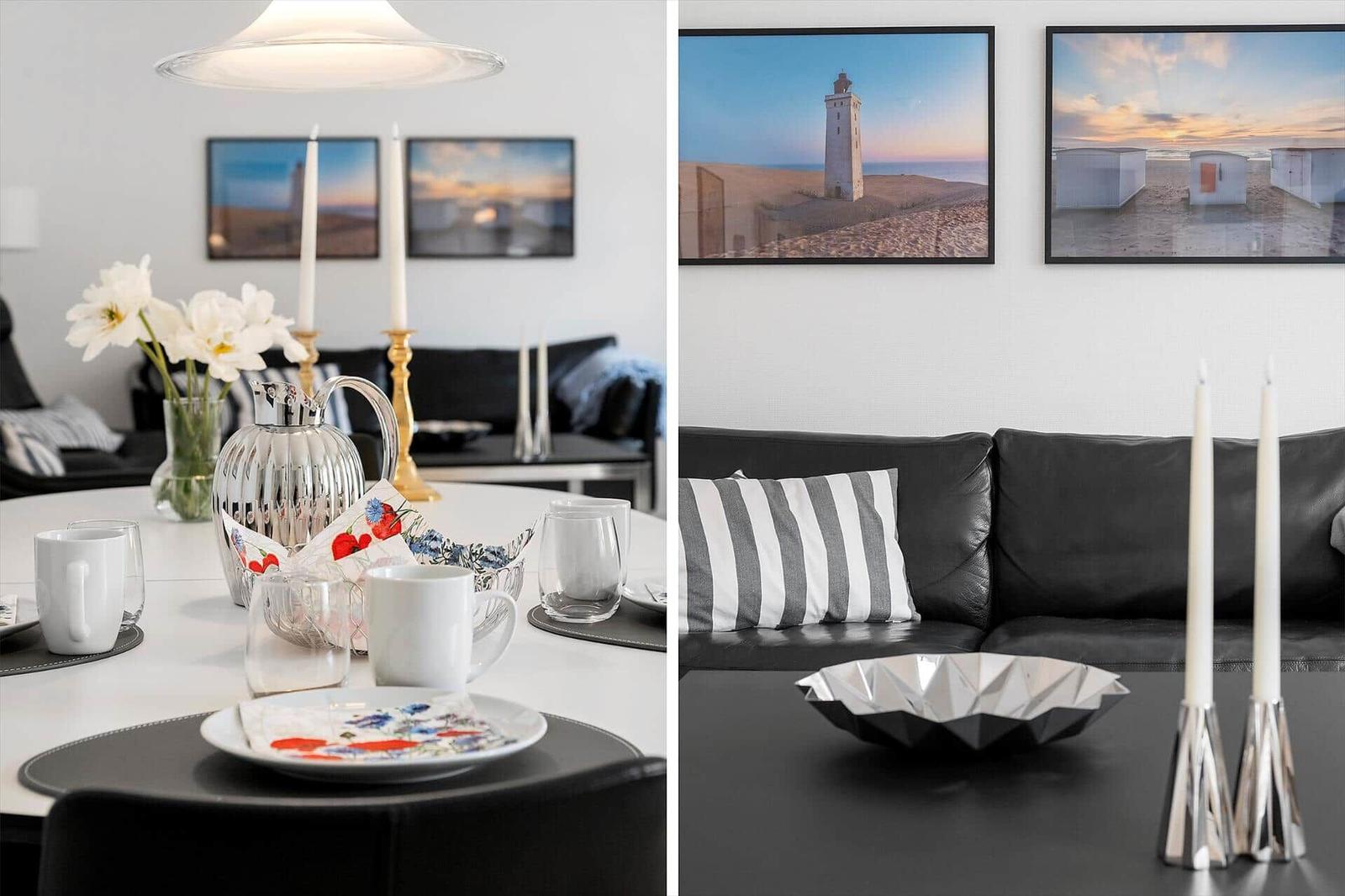 Essbereich mit Tisch, Stühlen und Wandbildern. Wohnbereich mit Sofa, Kissen und Tisch.