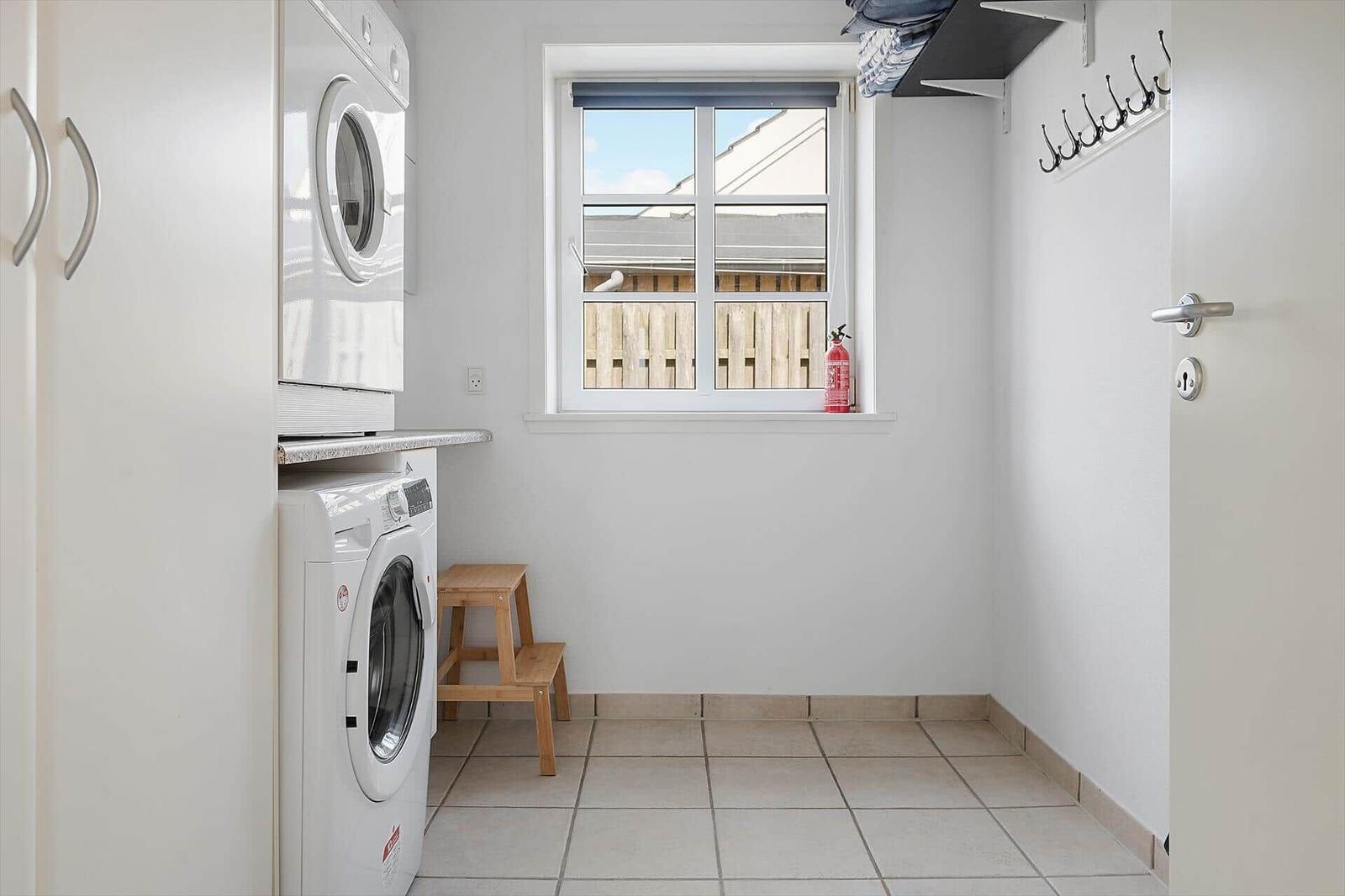 Wäscherei mit Waschmaschine, Trockner und Fenster