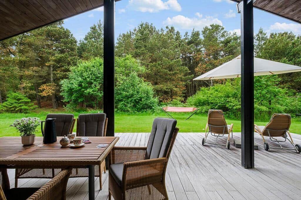 Terrace with seating group, table, and view into the forest.