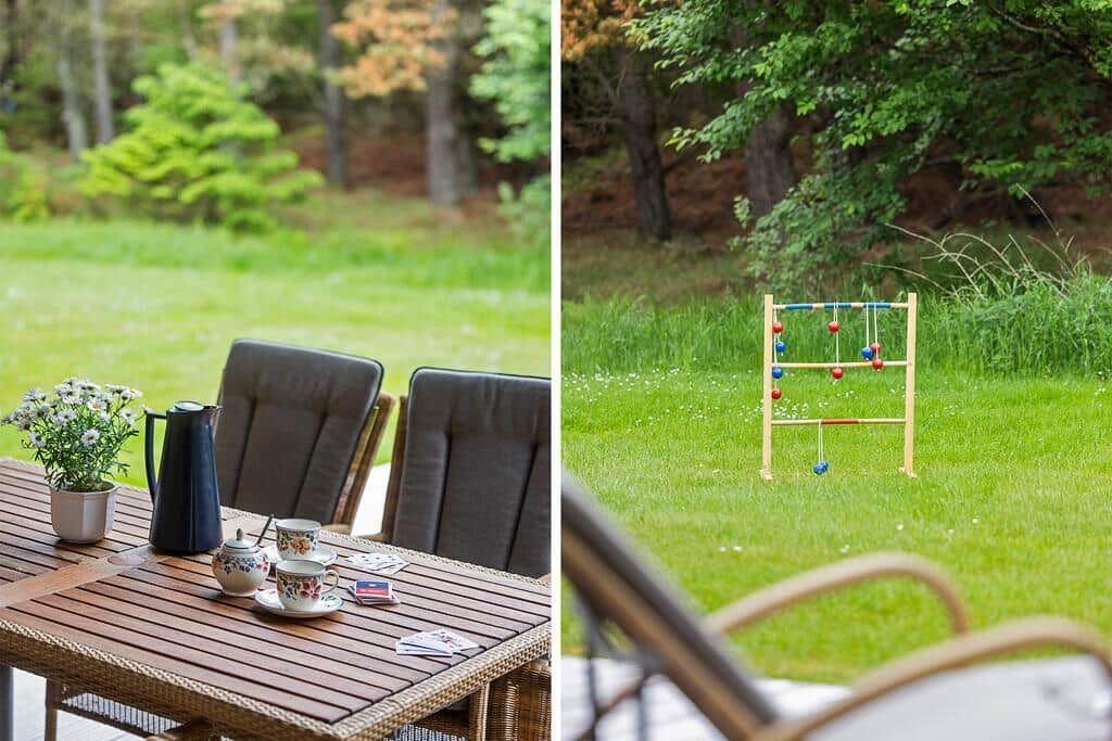 Terrace with table, chairs, and plant. Garden with wooden toy and grass.