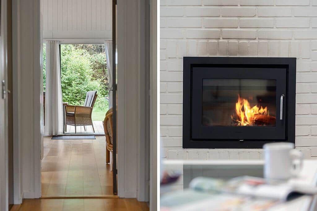 A fireplace with burning wood in a white brick wall. Through a door, a balcony with a chair is visible.