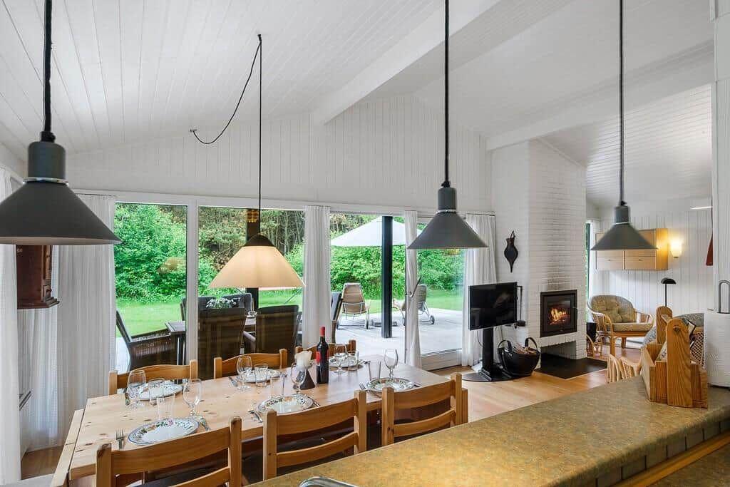 Dining room with wooden table, chairs, and large windows to the garden