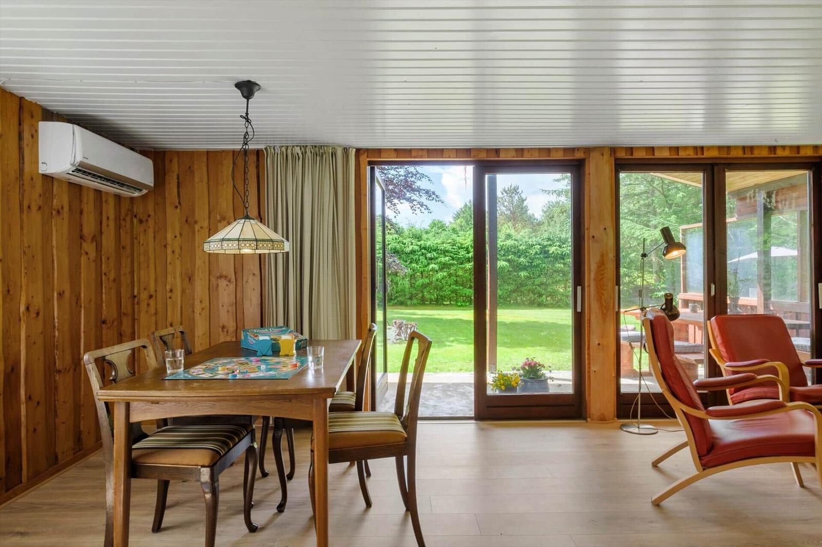 Essbereich mit Tisch, Stühlen und Blick auf den Garten.